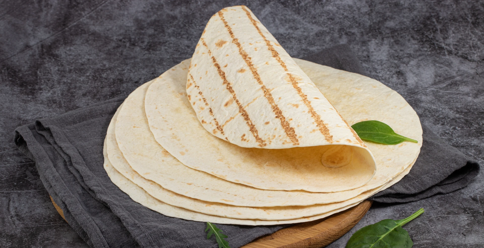 Grilled tortilla folded over spinach leaf